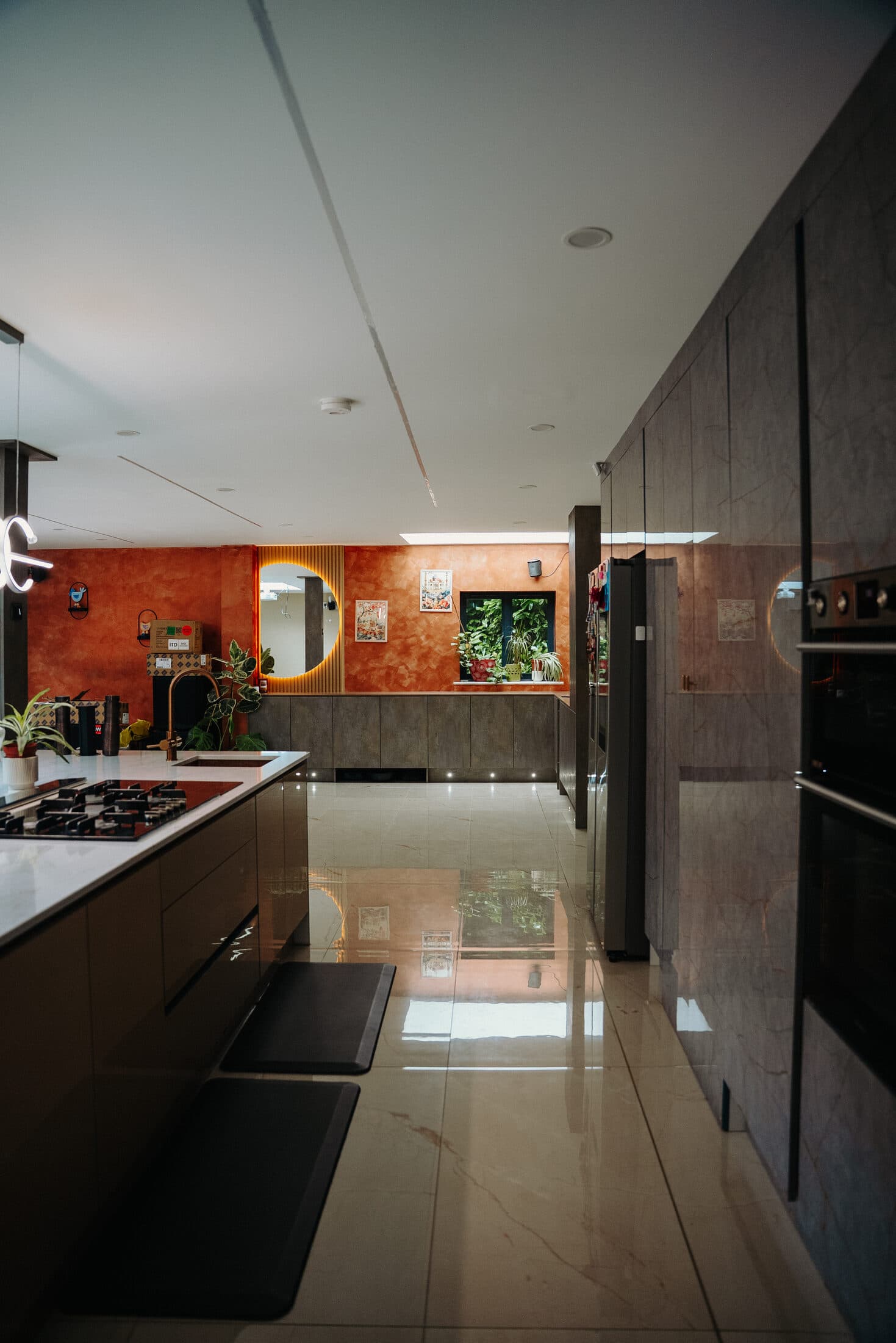 Kitchen island with white marble worktop, viewed from across the room by Sunny Interiors